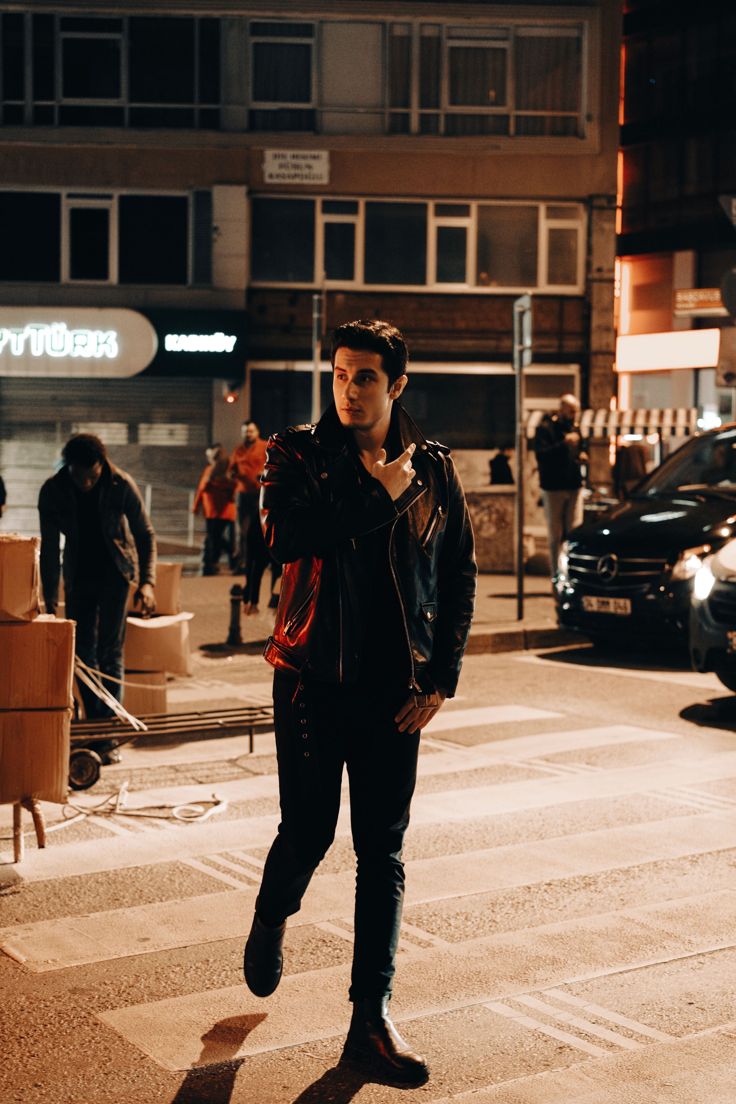 Model in leather jacket crossing the street