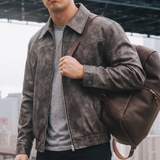 Men's distressed gray-brown faux leather jacket, lifestyle view with shoulder bag