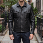Men's black button-front faux leather trucker jacket, street lifestyle view