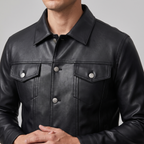 Men's black button-front faux leather trucker jacket, collar and chest detail