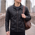 Men's black quilted-shoulder faux leather moto jacket, lifestyle view with shoulder bag