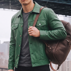 Men's green button-front faux leather trucker jacket, lifestyle view with shoulder bag