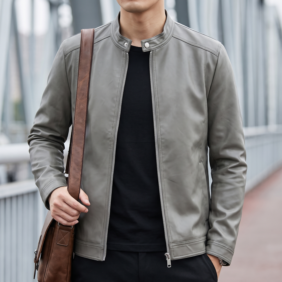 Men's gray minimalist faux leather racer jacket, lifestyle view with shoulder bag