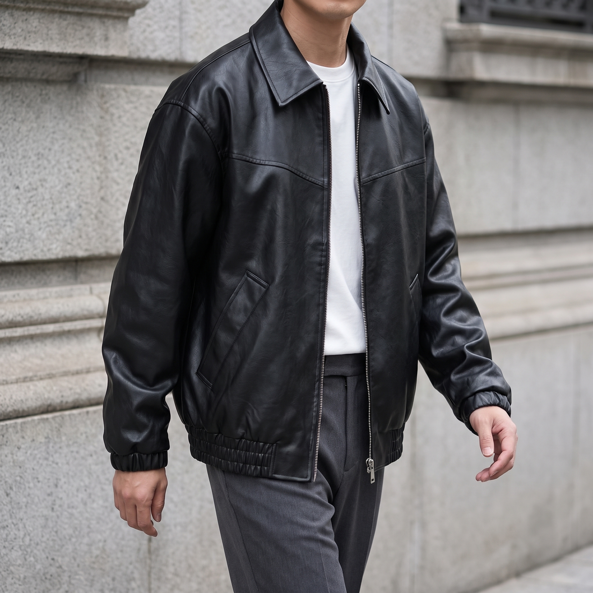 Men's black relaxed faux leather bomber jacket, three-quarter lifestyle view