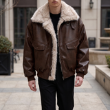 Men's brown faux leather aviator jacket with faux fur collar, walking lifestyle view