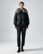 Black padded jacket, full front view with tailored trousers.