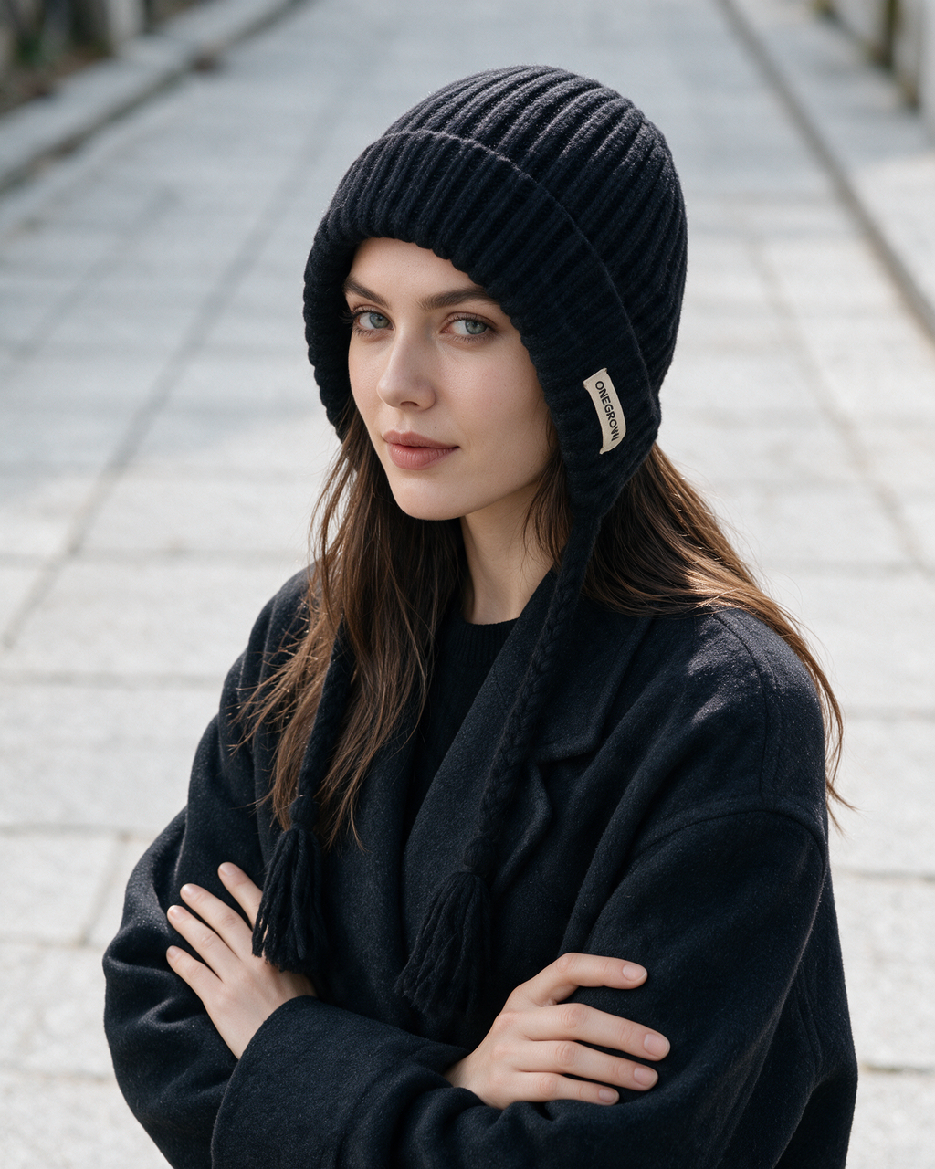 Women's knit earflap hat with braided ties — Black, on model, styled view
