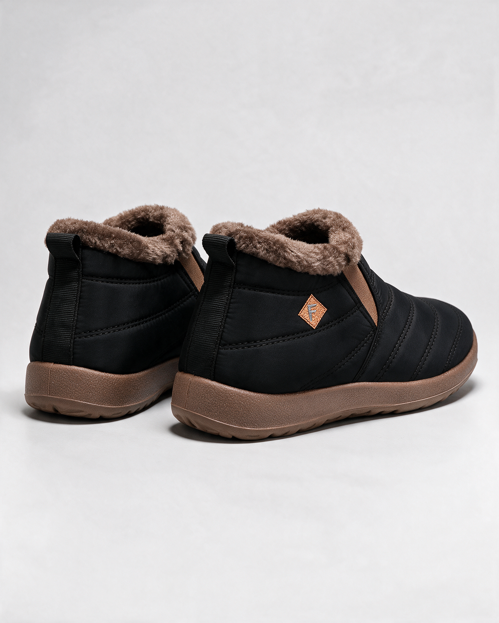Black ankle boots with brown trim — rear