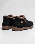 Black ankle boots with brown trim — rear