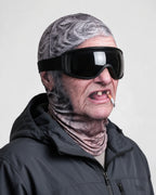 Printed fabric mask worn with ski goggles. Goggles and clothing not included.