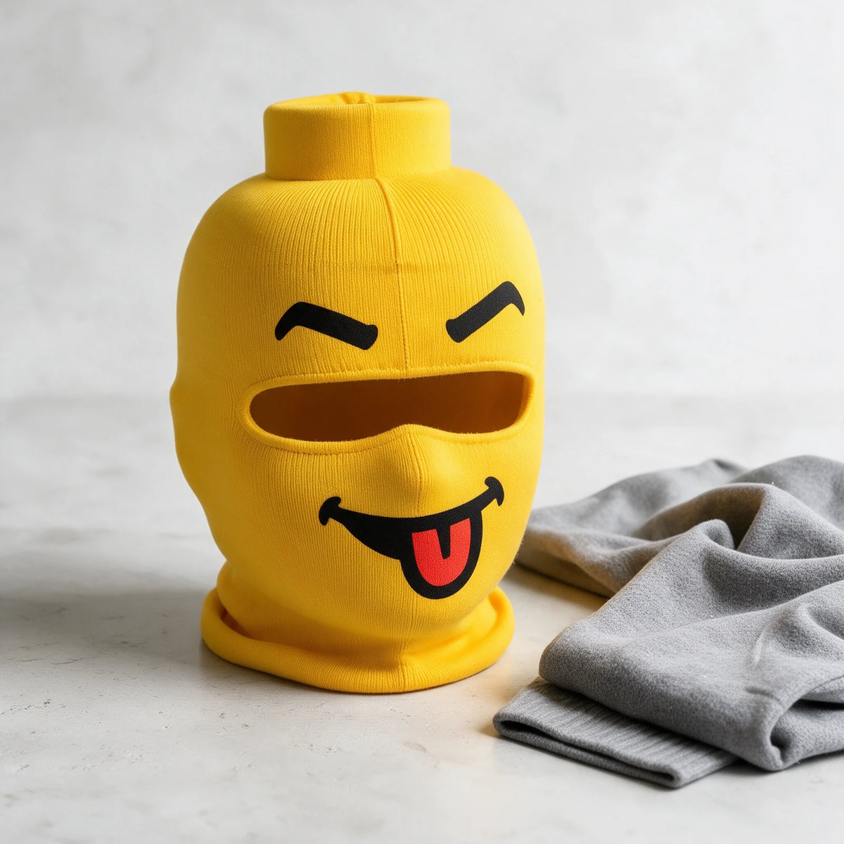 Cheeky Tongue fabric mask beside a gray sweater; mask only